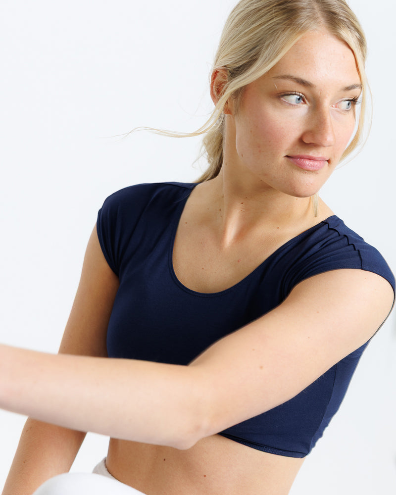 Woman wearing a navy blue top against a white background