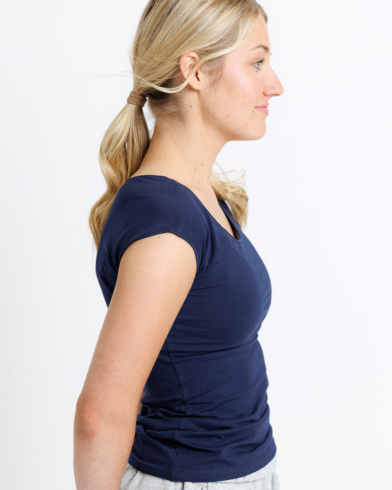 Woman wearing a navy blue top against a white background
