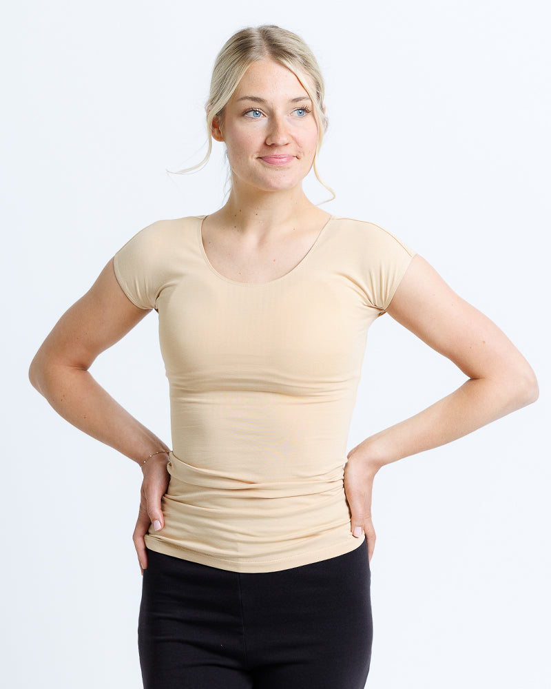 Woman wearing a beige t-shirt against a white background