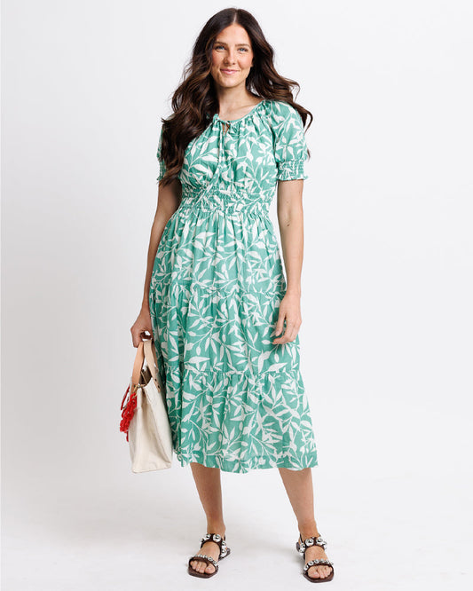 Woman wearing a green floral dress on a white background