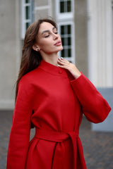 Woman wearing a red coat with a blurred background