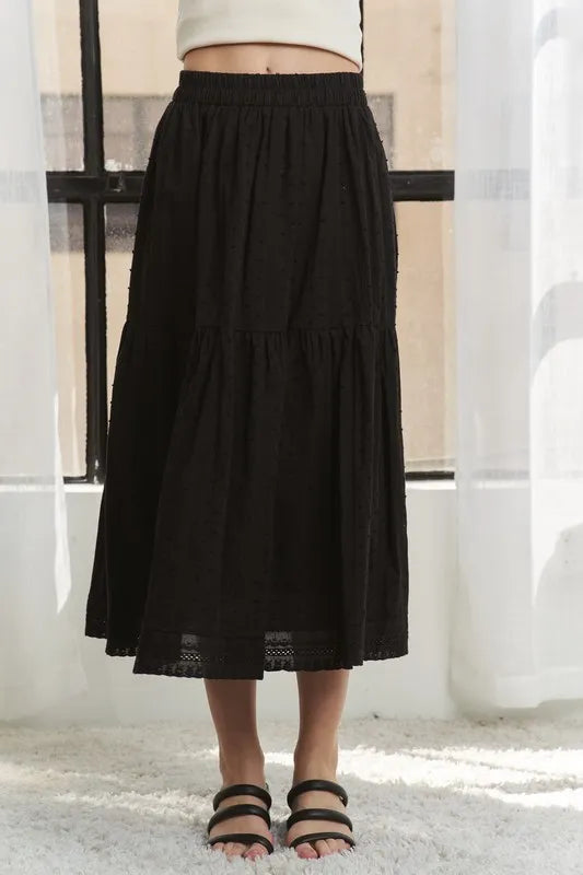 Black tiered skirt worn by a person in a minimal indoor setting