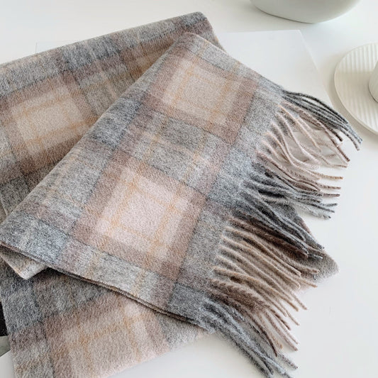 Plaid blanket with fringes on a white surface