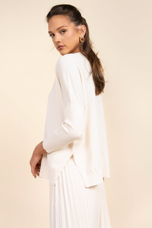 Woman wearing a white outfit against a beige background