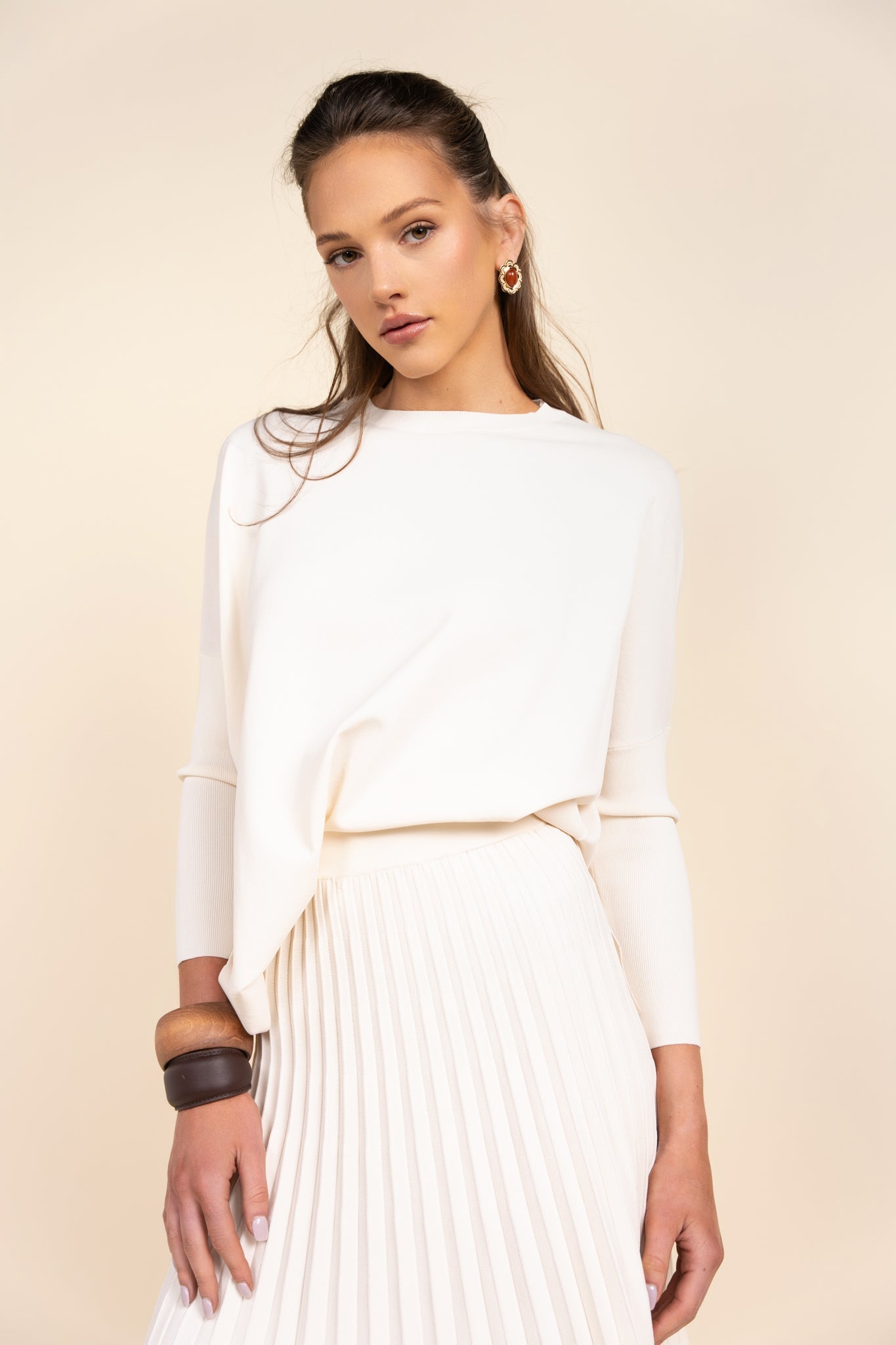 Woman wearing a white dress with a beige background