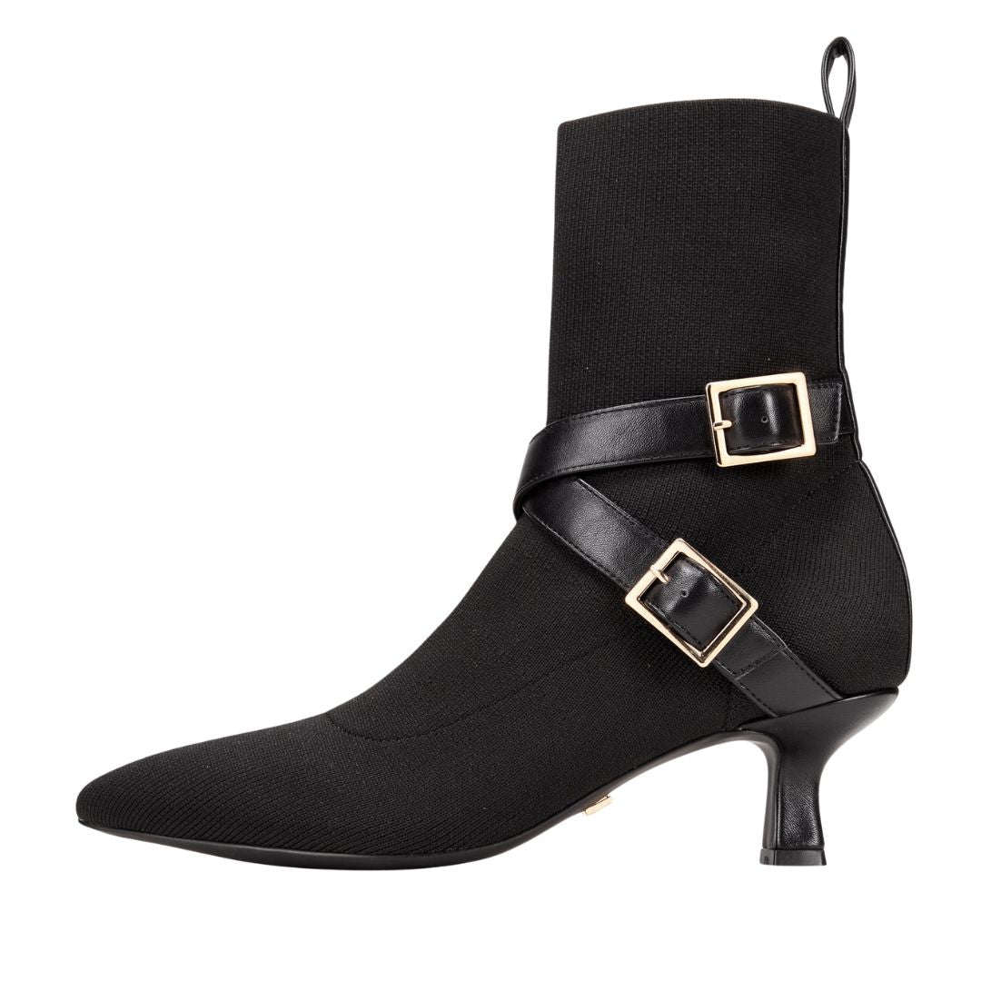 Black ankle boot with gold buckles on a white background