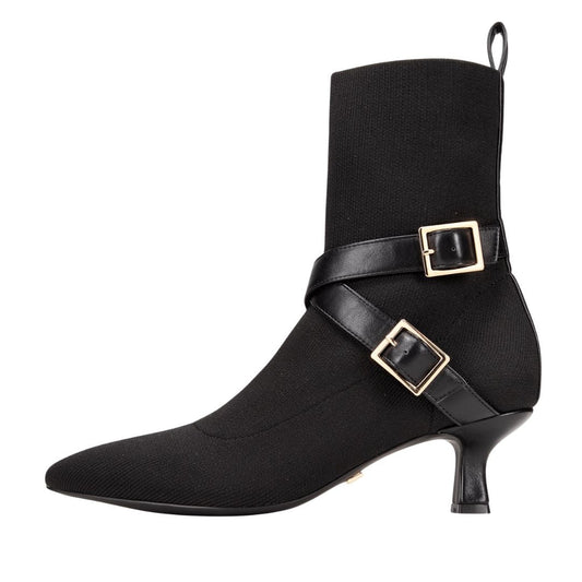 Black ankle boot with gold buckles on a white background