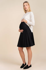 Woman wearing a black skirt and white top against a beige background