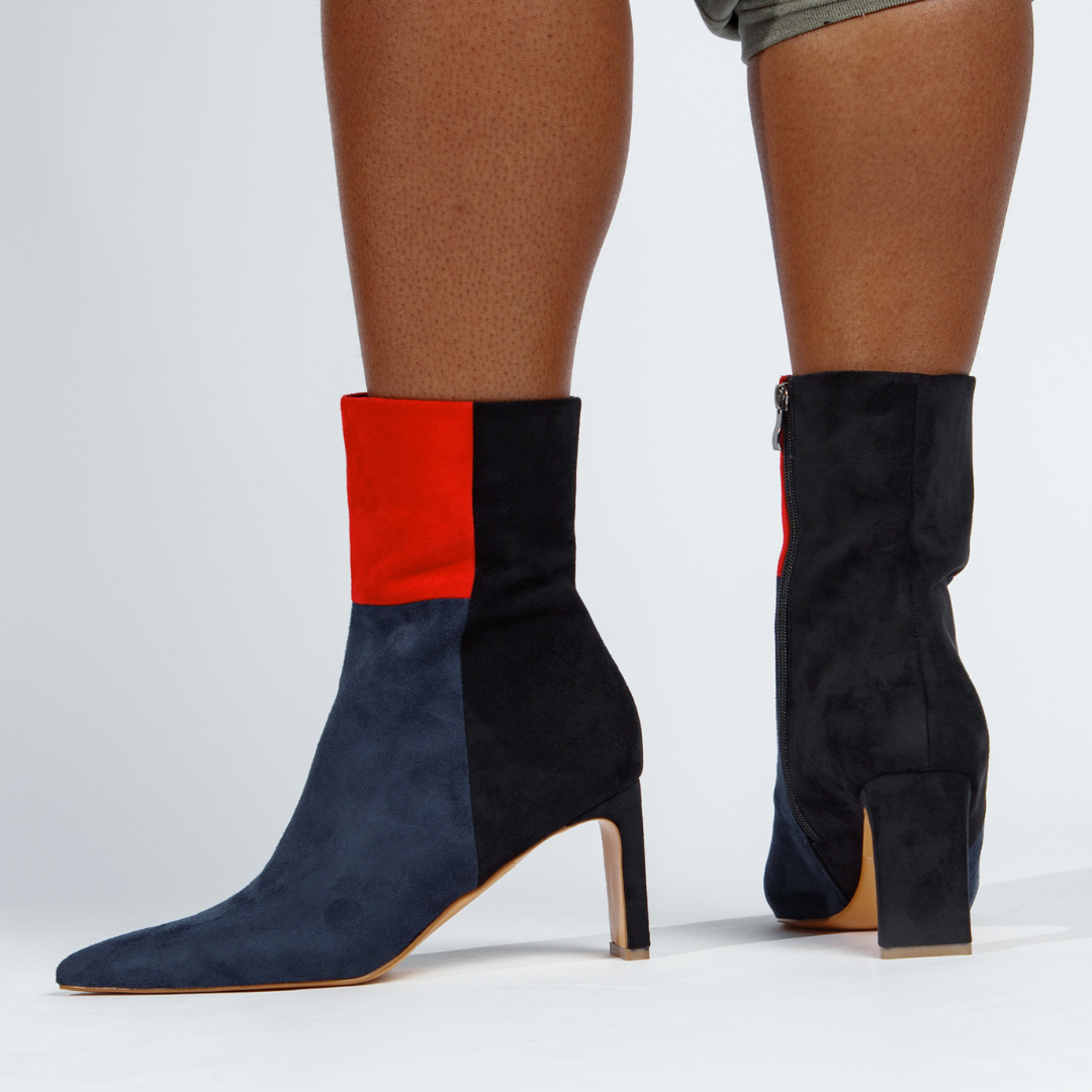 Black and red sock boots worn by a person on a white background