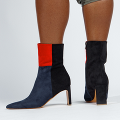 Black and red sock boots worn by a person on a white background