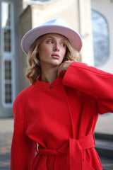 Woman wearing a red coat and pink hat outdoors
