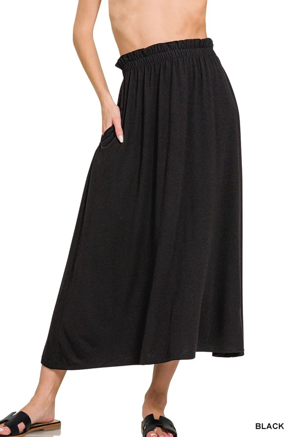 Black skirt worn by a person on a white background