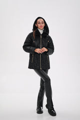 Person wearing a black hooded jacket on a white background