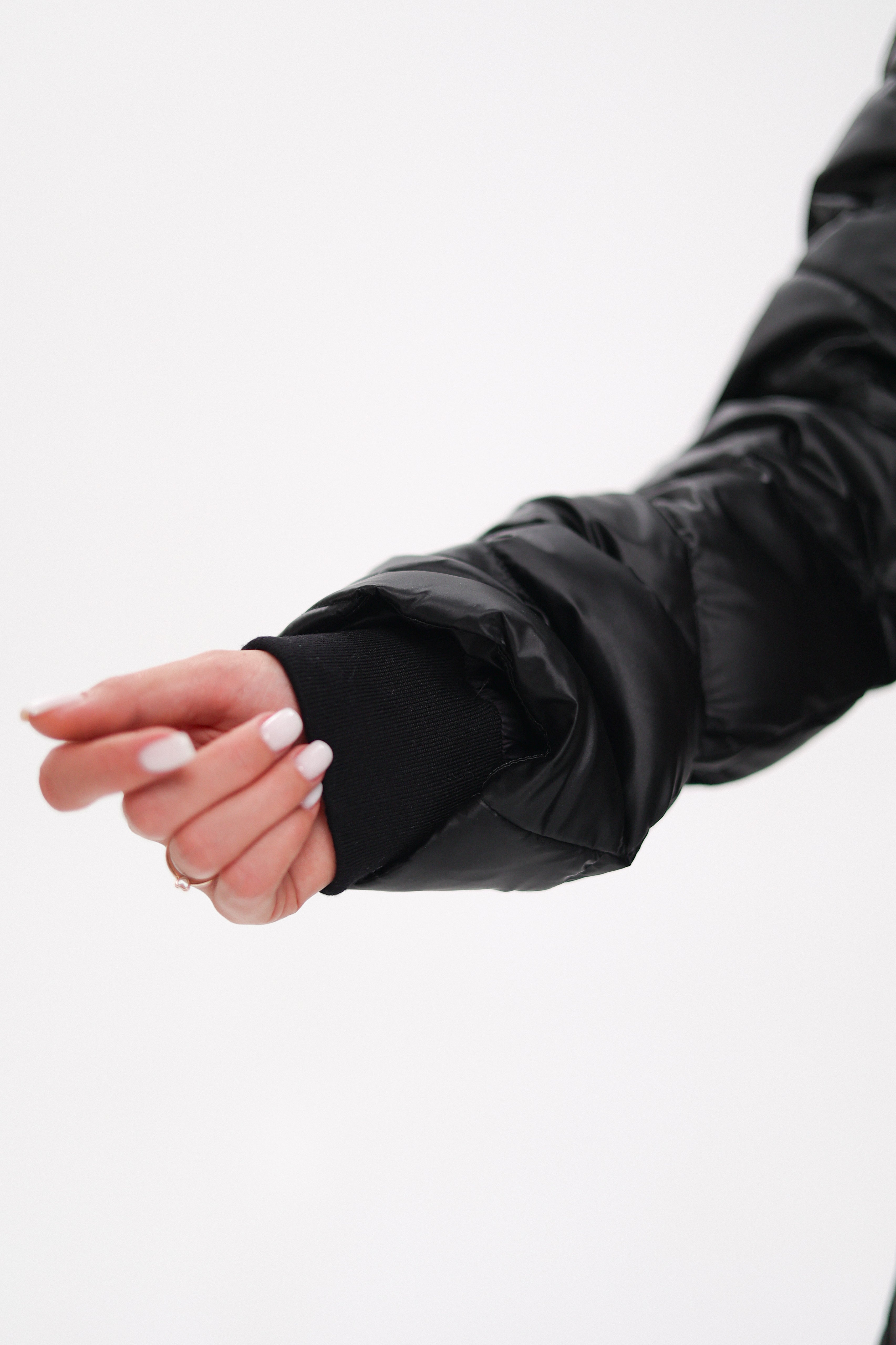 Person wearing a black jacket with a white background