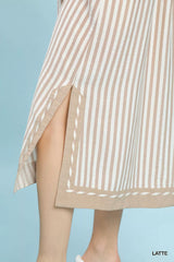 Beige and white striped dress with a slit on a light blue background