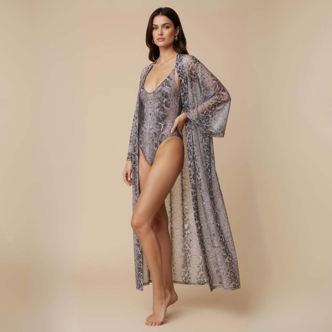 Woman wearing a patterned swimsuit and cover-up against a beige background