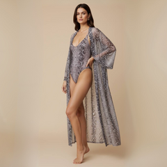 Woman wearing a patterned swimsuit and cover-up against a beige background