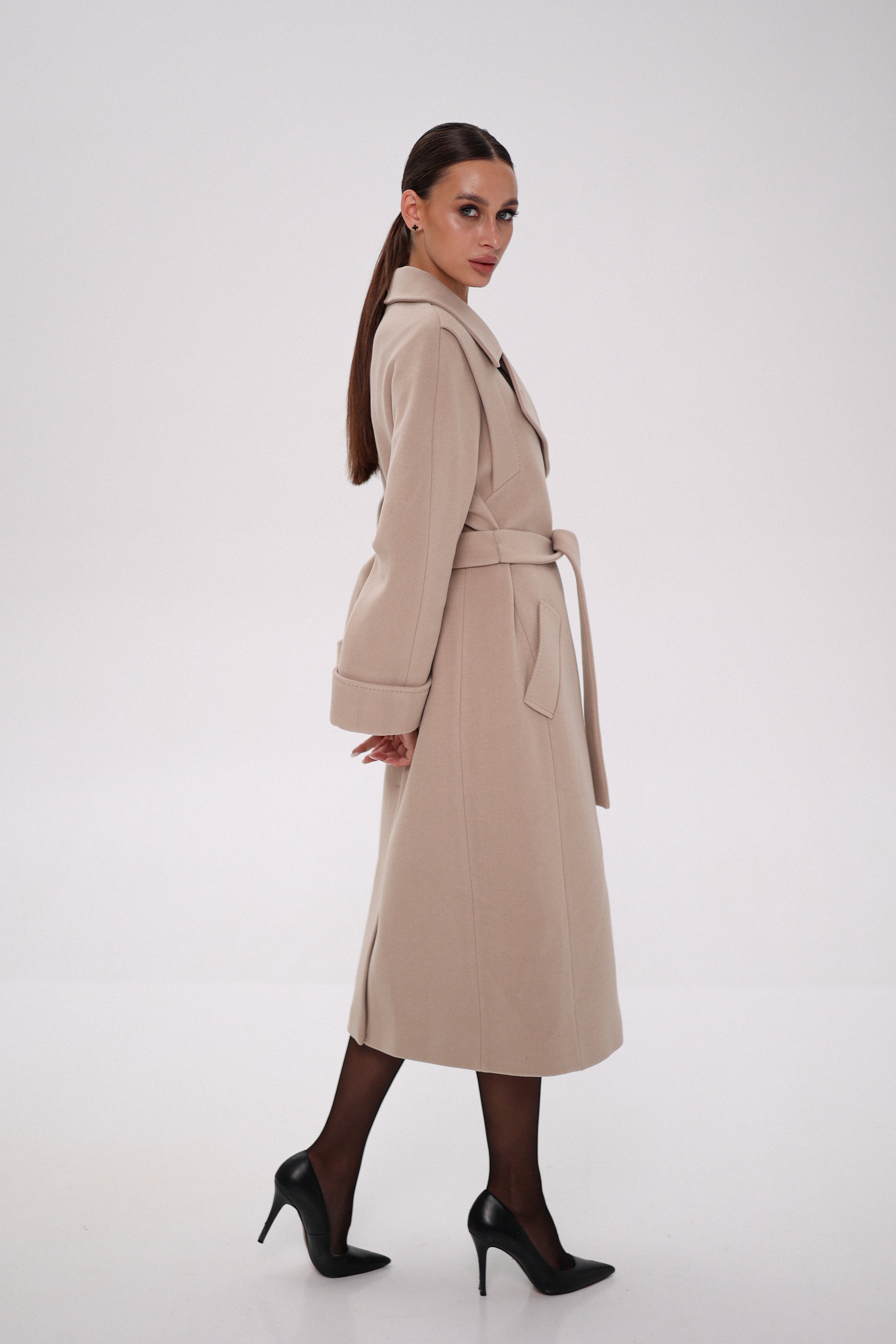 Woman wearing a beige trench coat on a white background