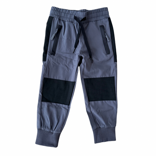 Gray jogger pants with black patches on a white background