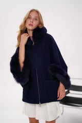 Woman wearing a navy blue coat with fur trim on a white background