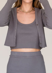 Person wearing a gray ribbed outfit with a matching cardigan on a plain background