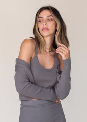 Woman wearing a gray ribbed knit outfit against a plain background