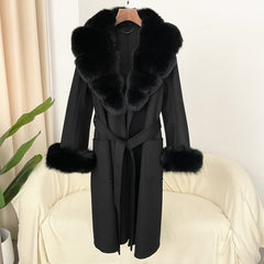 Black coat with fur collar and cuffs on a chair against a neutral background