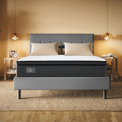 Gray upholstered bed with white mattress in a bedroom setting