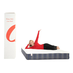 Person lying on a mattress with a large branded box next to it on a white background