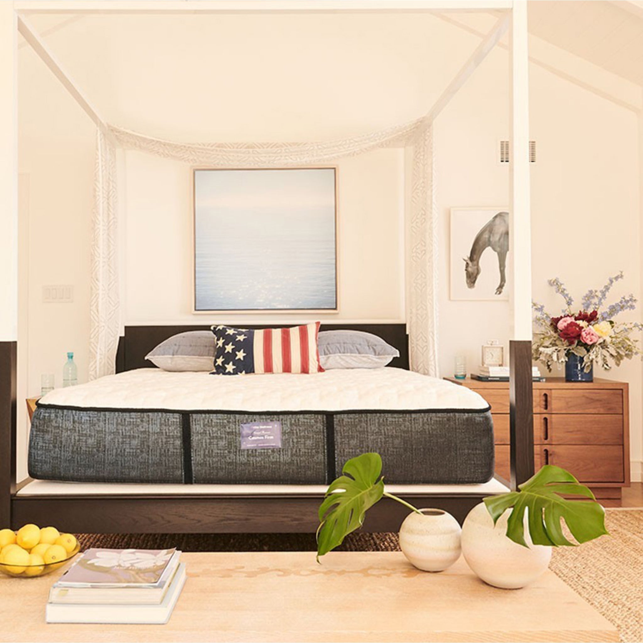 Bedroom with a bed featuring an American flag pillow, wooden dresser, and decor items.