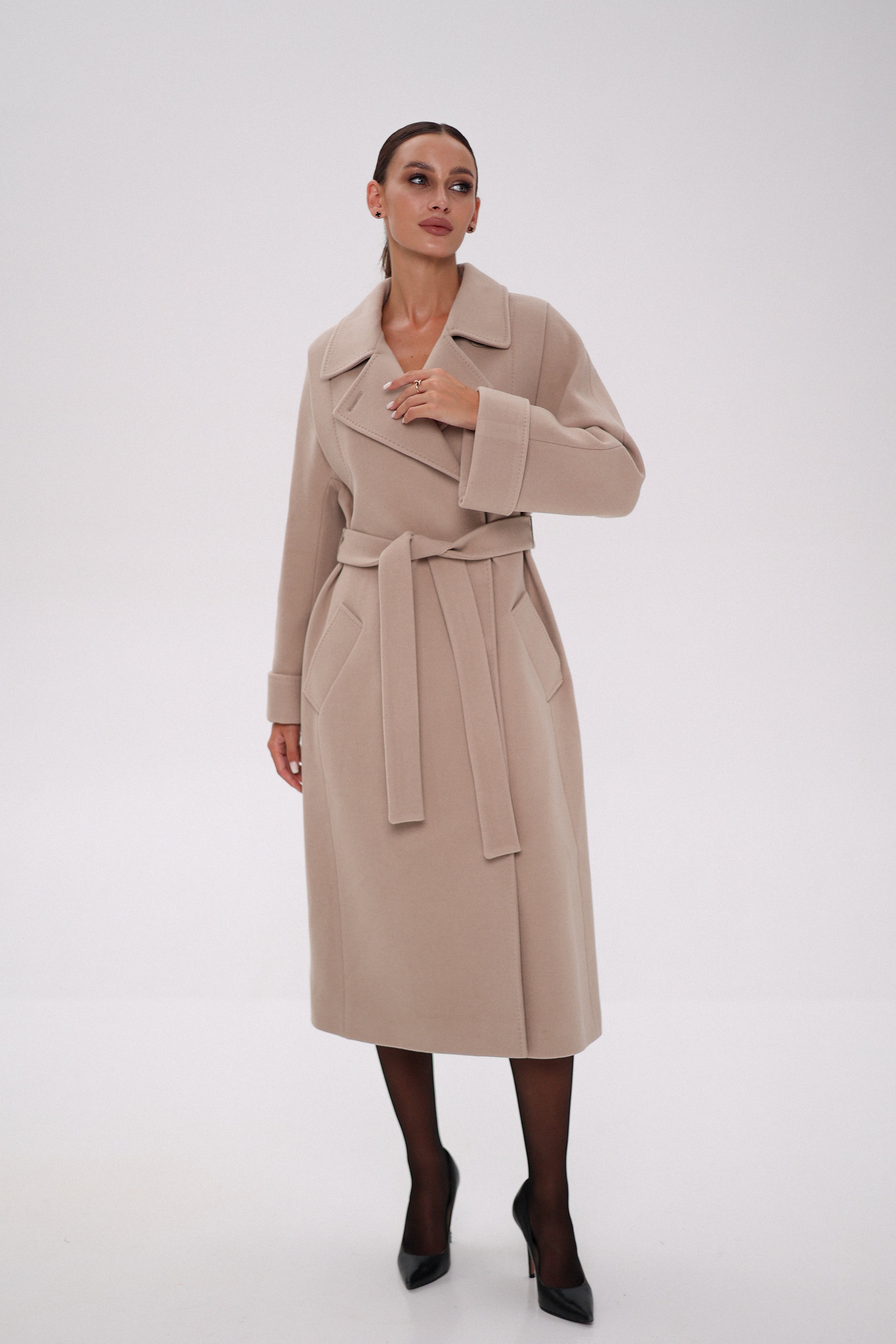 Woman wearing a beige trench coat on a white background