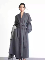 Woman wearing a gray coat with a white background