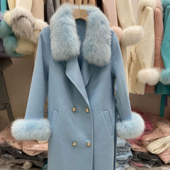 Blue coat with fur trim hanging on a rack among other coats.