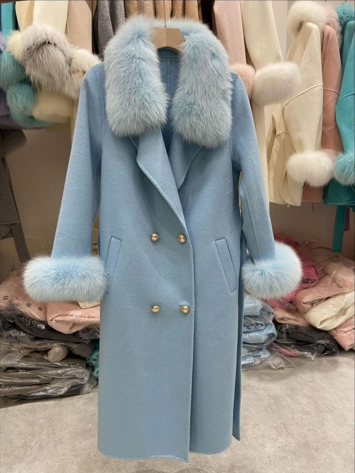 Light blue coat with fur collar and cuffs in a store setting