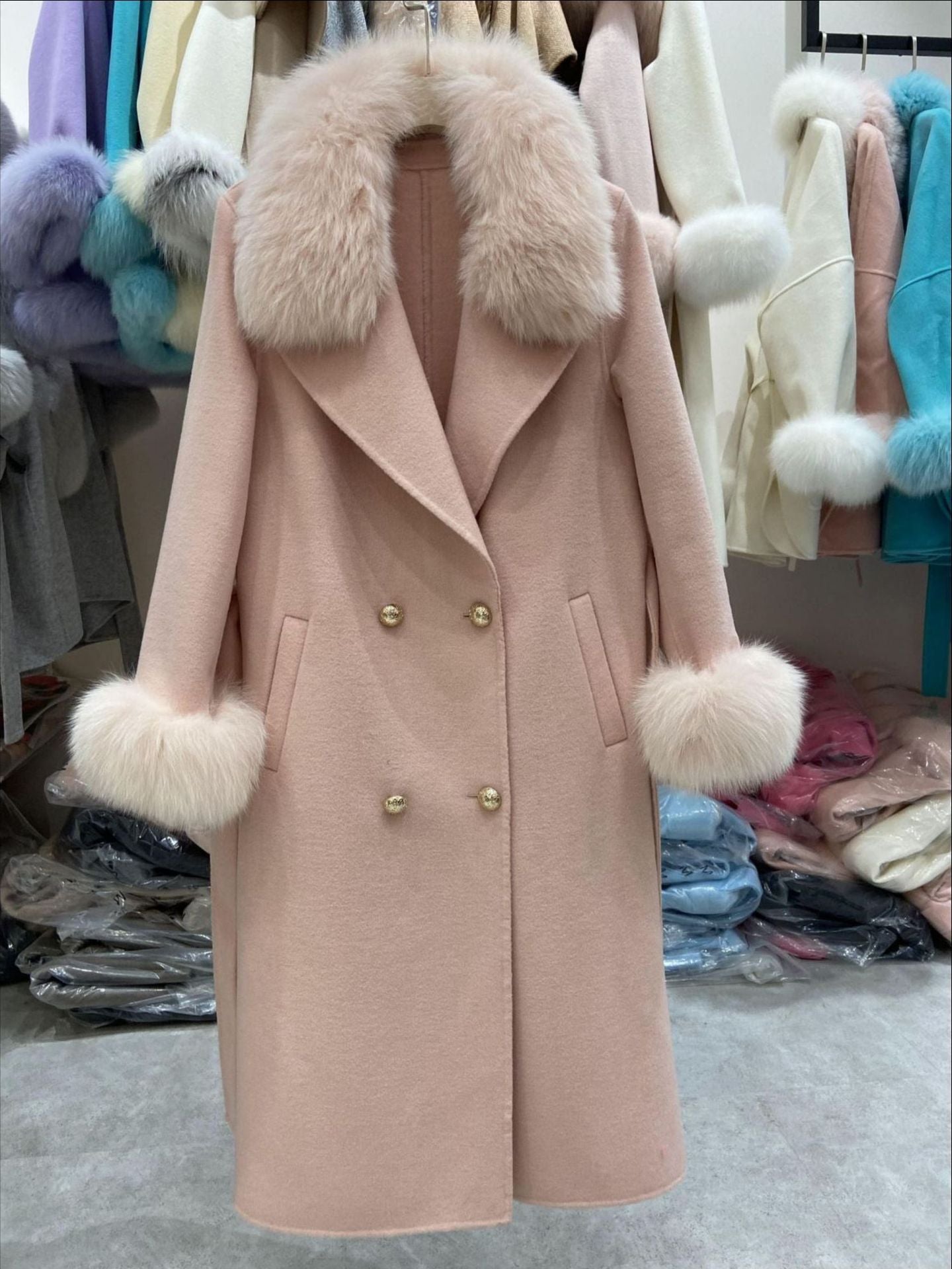 Pink coat with fur trim in a store setting