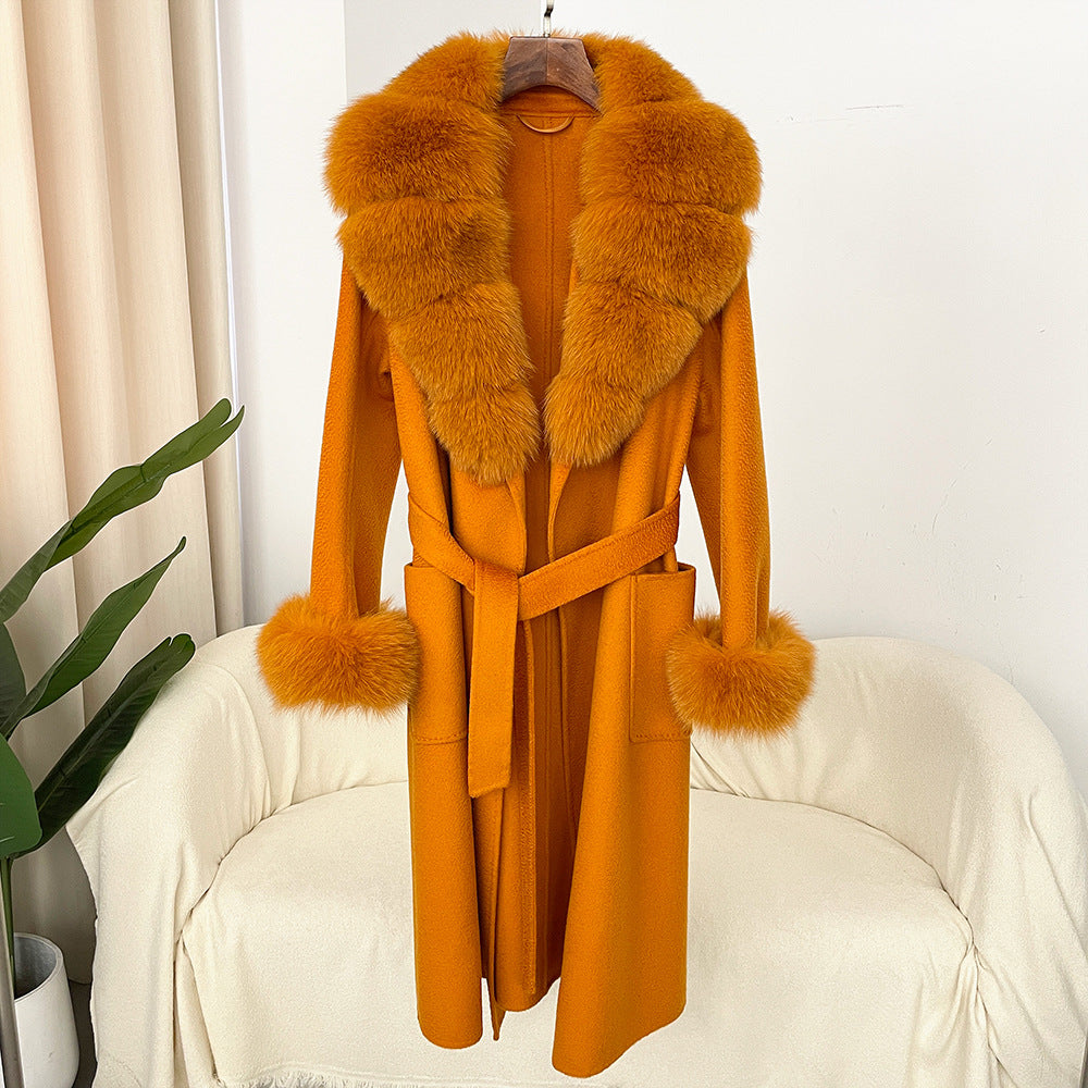 Mustard yellow coat with fur collar on a chair against a white wall