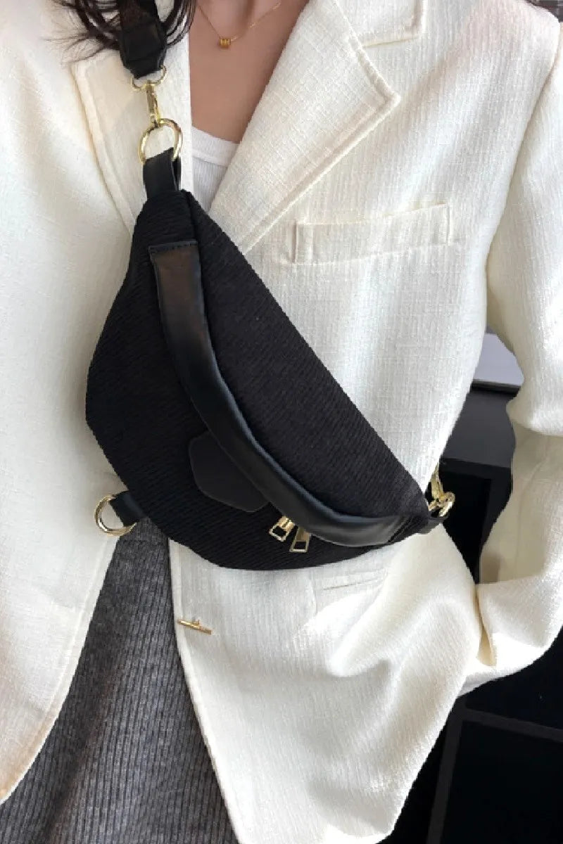 Person wearing a black waist bag with a white blazer