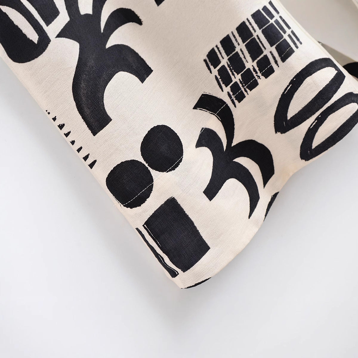 Fabric swatch with black abstract patterns on a beige background