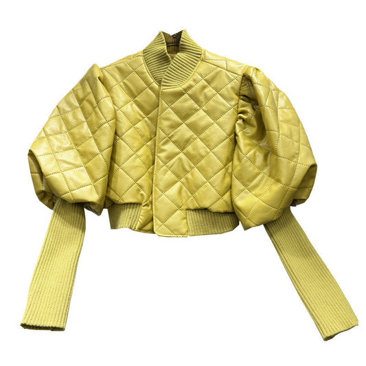 Yellow quilted jacket with ribbed sleeves on a white background