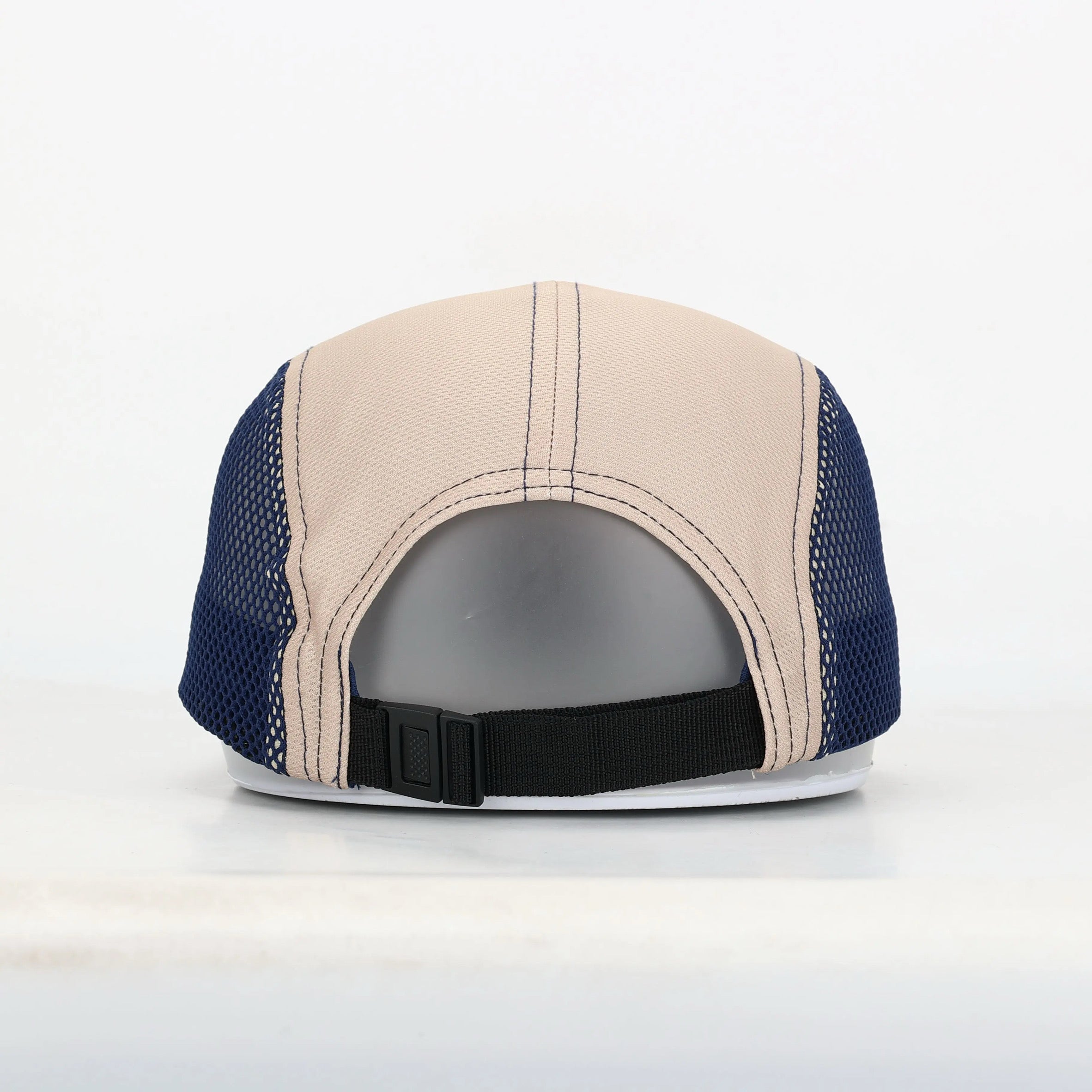 Back view of a cap with beige and blue design on a white background