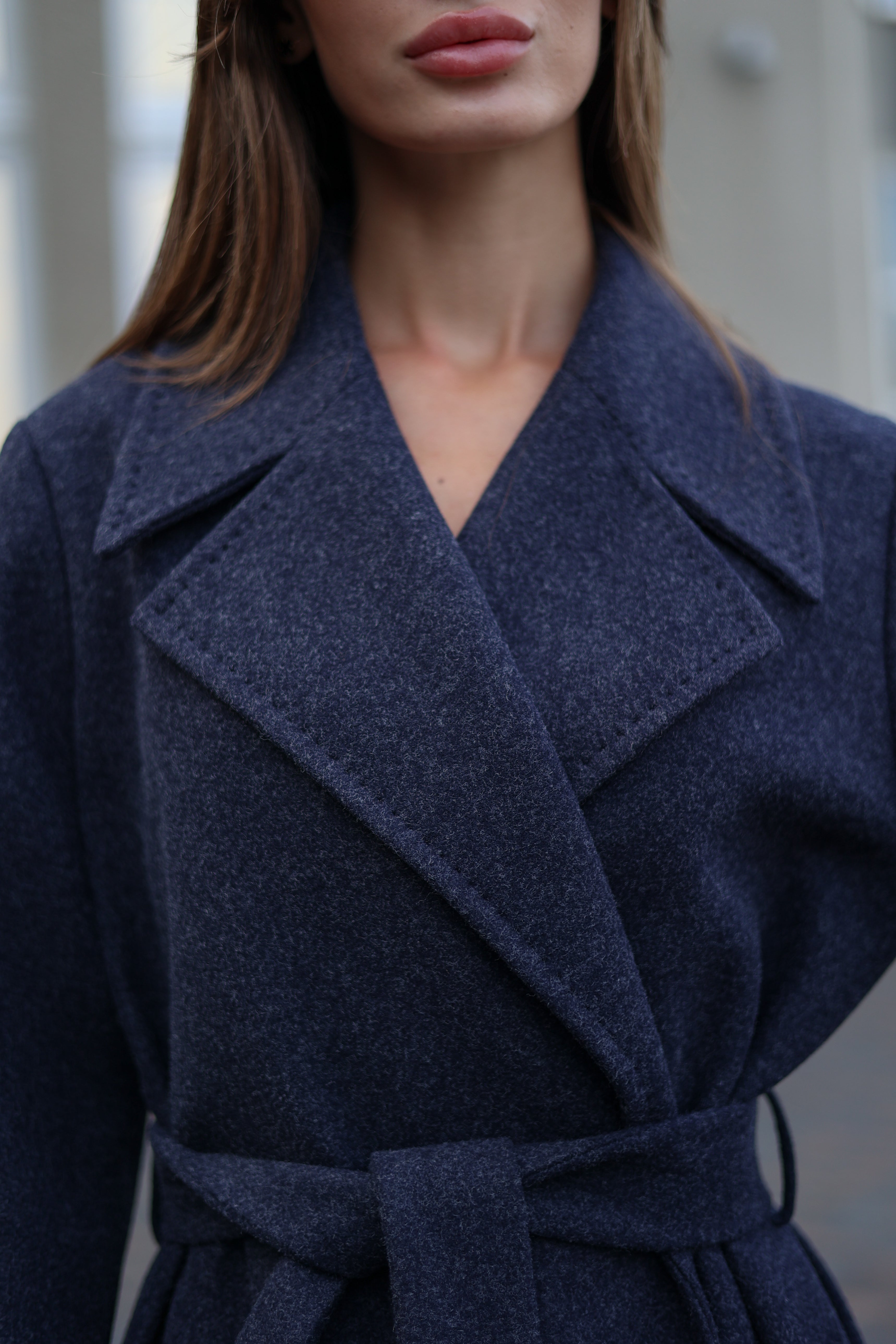 Navy blue coat worn by a person with a blurred background