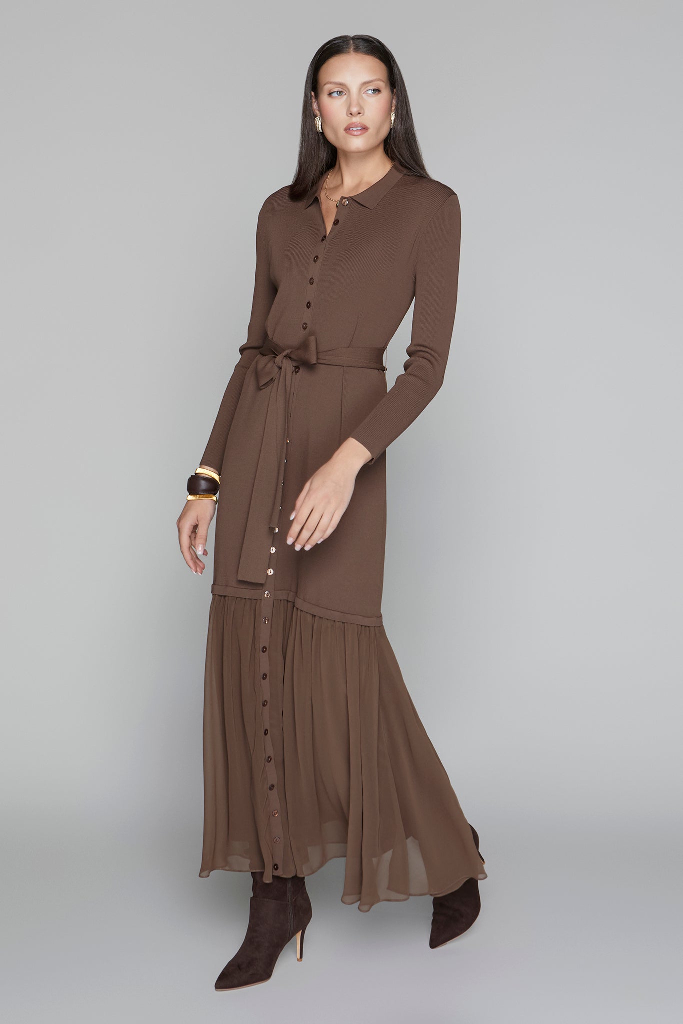 Woman wearing a brown dress with a belt on a gray background
