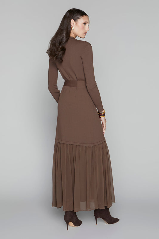 Woman wearing a brown dress with a belt on a gray background