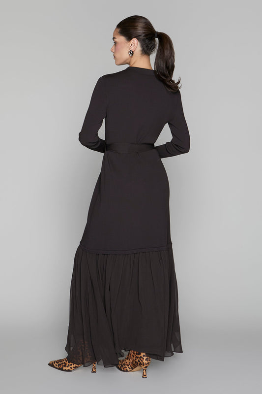 Woman wearing a black dress with a plain background