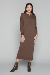 Woman wearing a brown dress and boots on a gray background