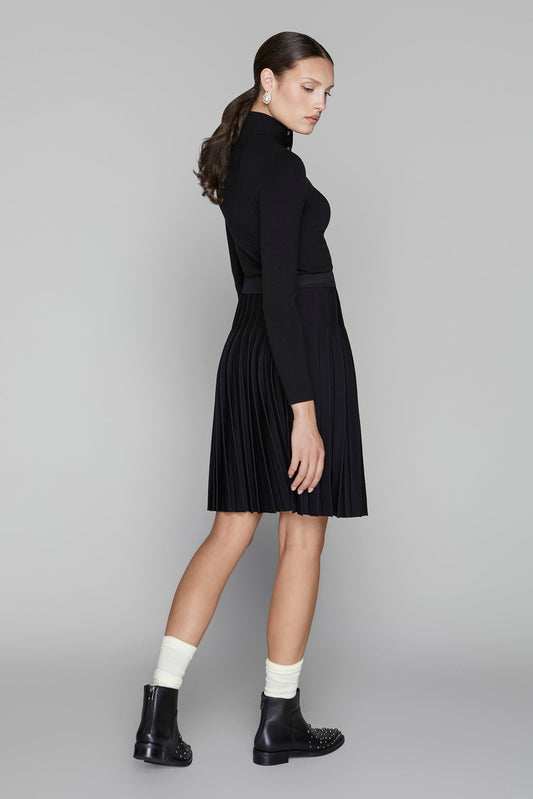 Woman wearing a black dress with a plain background