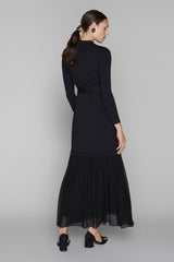 Woman wearing a black dress with a belt on a gray background