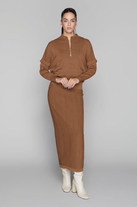 Woman wearing a brown outfit with a plain background