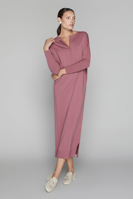 Woman wearing a mauve dress on a gray background