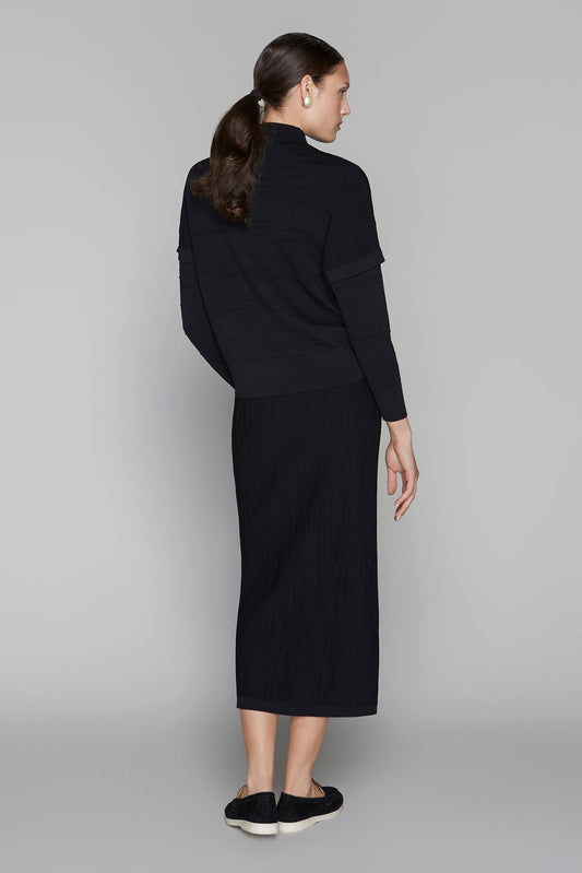 Woman wearing a black outfit on a gray background